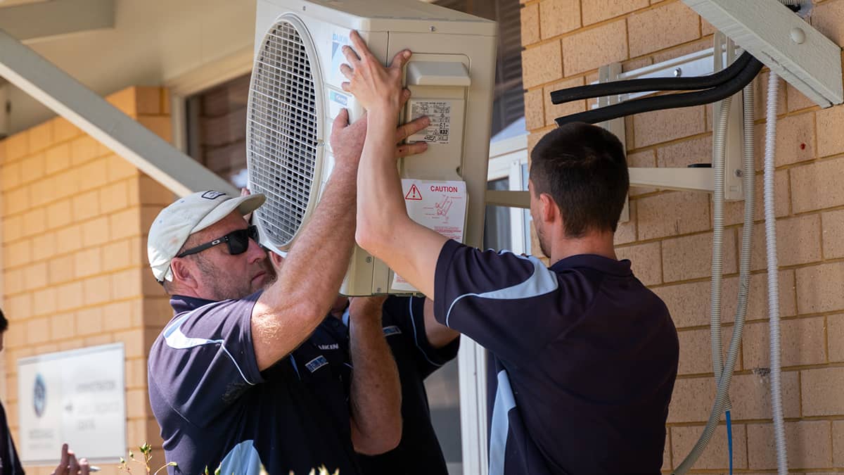 Split system installation configuration involves the outdoor unit mounted with brackets on the outside of a double brick wall.