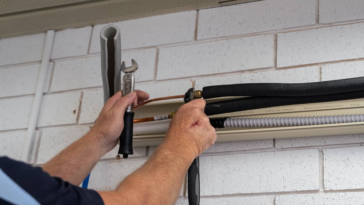 During air con installation, pipes go through the wall and down to an outdoor unit placed on the ground directly below.