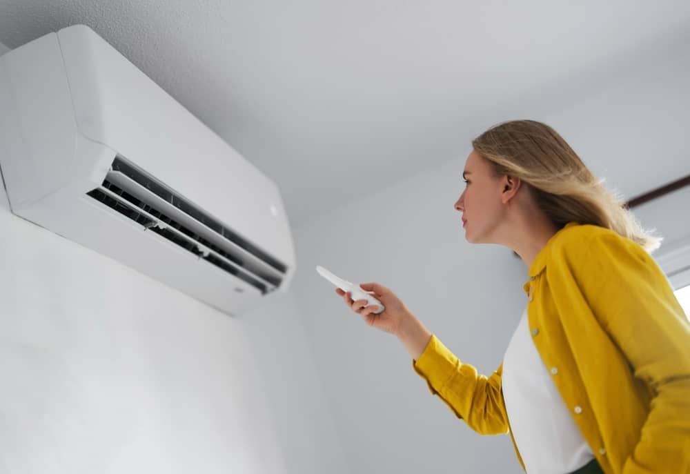 female turning on an air conditioner