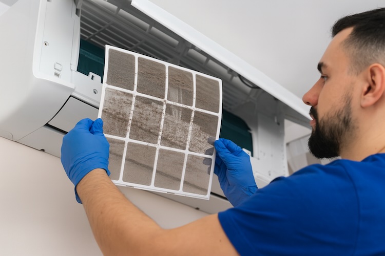 man holding split system filter