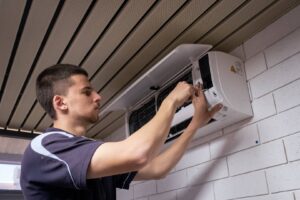 Licensed technician installing a wall-mounted split system air conditioner in Perth, Western Australia