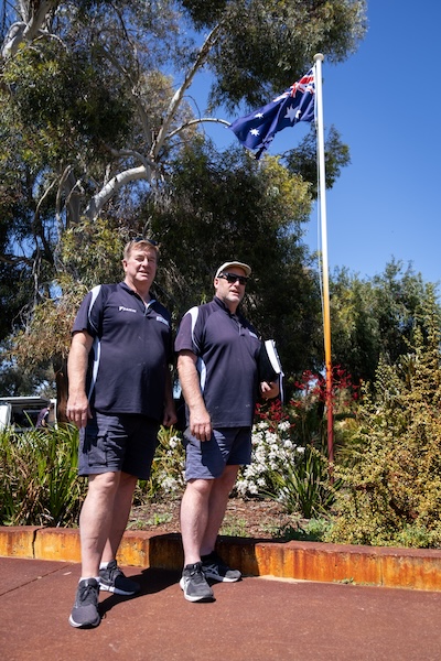 Glen and Wayne owners of air-cond installs wa standing infront of australia flag at garden in perth city