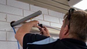 air con technician fixing air con pipe